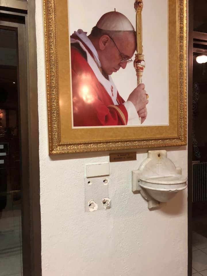 Beneath a portrait of Pope Francis is the outline of where the stolen parish poor box was anchored to the wall at Our Lady of Mount Carmel.